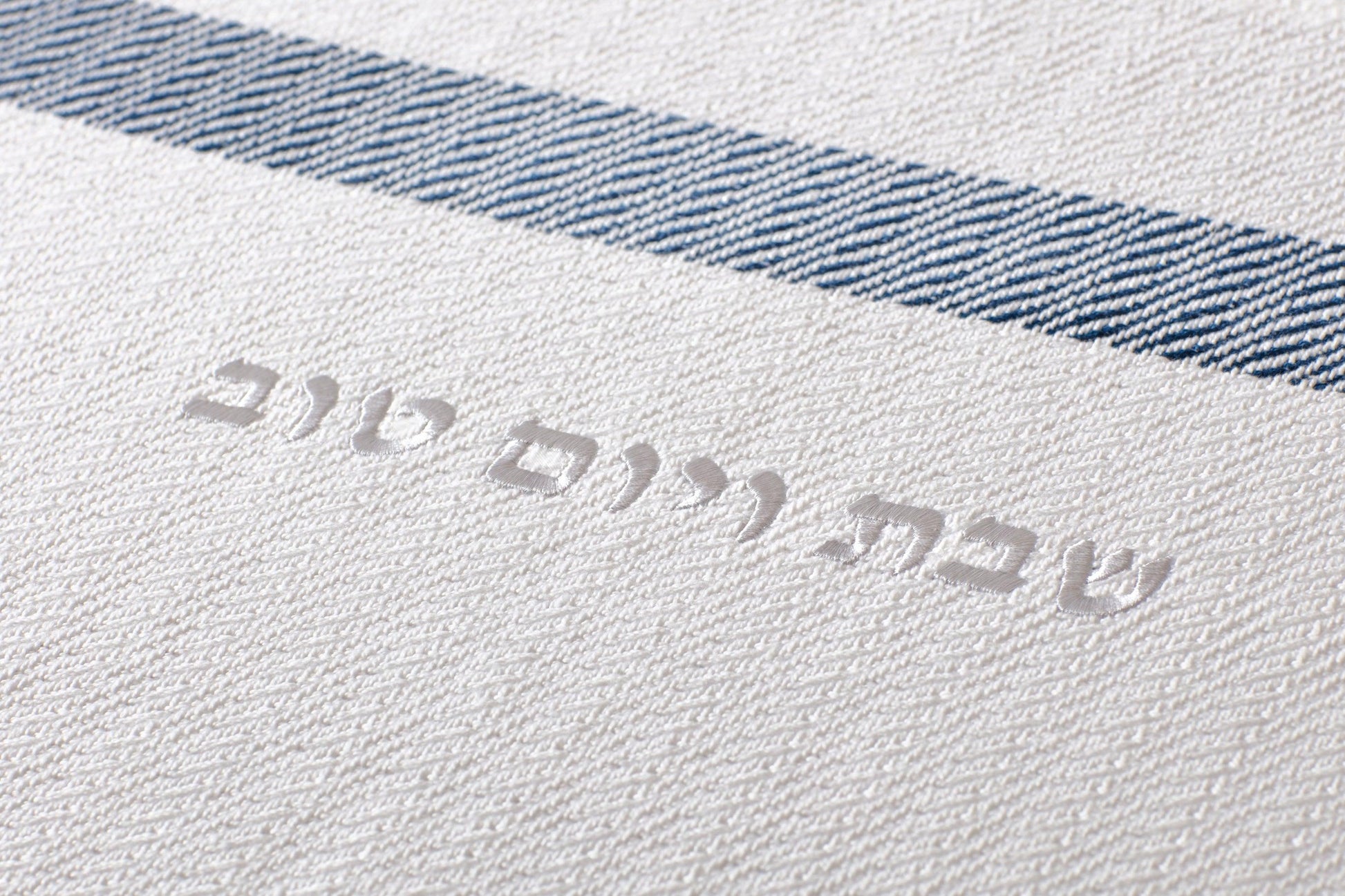 Close up of the woven text on the Challah Cover reading "שבת ויום טוב"
