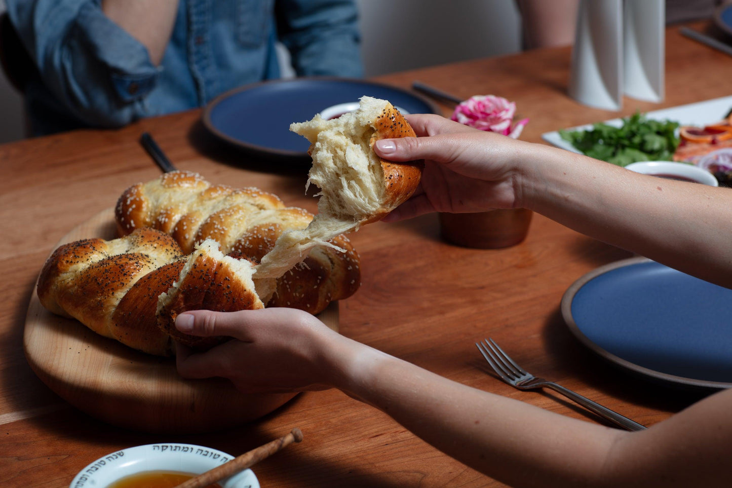 Challah resting on handmade wooden tray at Shabbat Dinner