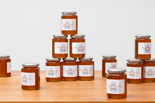 “Jars of raw Colorado wildflower honey, beautifully golden and pure, showcasing its natural richness. Handcrafted in 10oz jars, perfect for Rosh Hashanah or everyday enjoyment. Available at Green Judaica.”