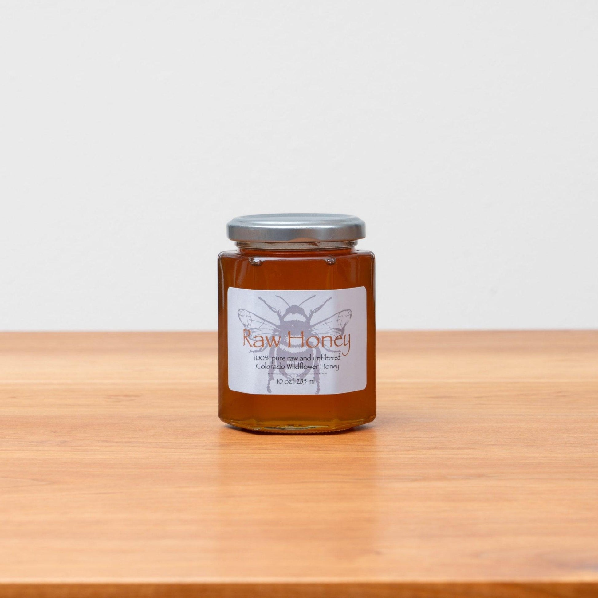 Jar of raw Colorado wildflower honey, beautifully golden and pure, showcasing its natural richness. Handcrafted in 10oz jars, perfect for Rosh Hashanah or everyday enjoyment. Available at Green Judaica.