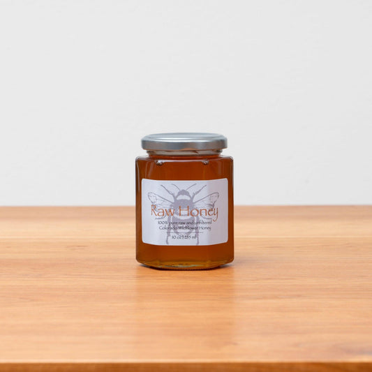 Jar of raw Colorado wildflower honey, beautifully golden and pure, showcasing its natural richness. Handcrafted in 10oz jars, perfect for Rosh Hashanah or everyday enjoyment. Available at Green Judaica.