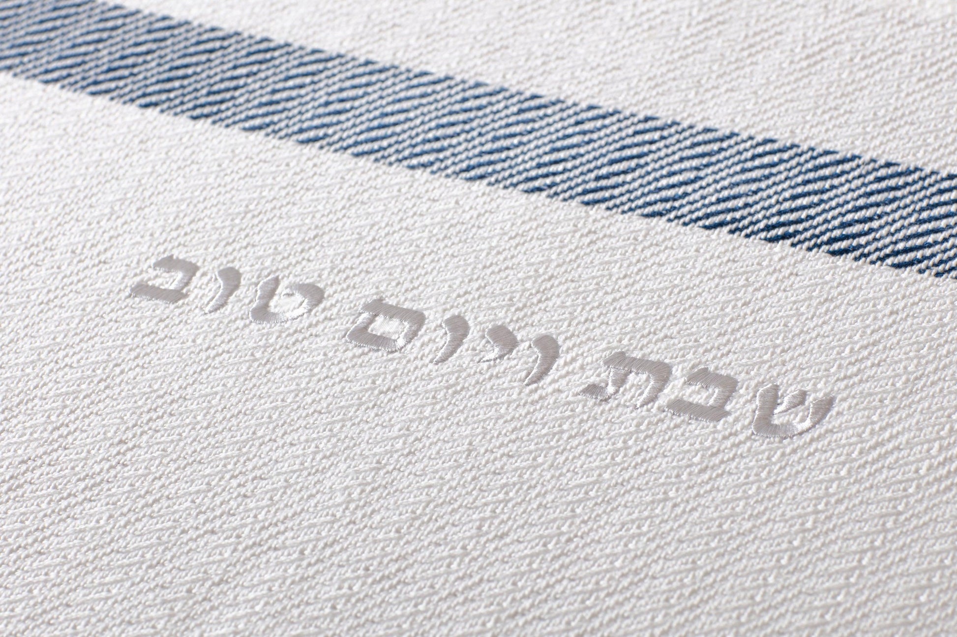 Close up of the woven text on the Challah Cover reading "שבת ויום טוב"