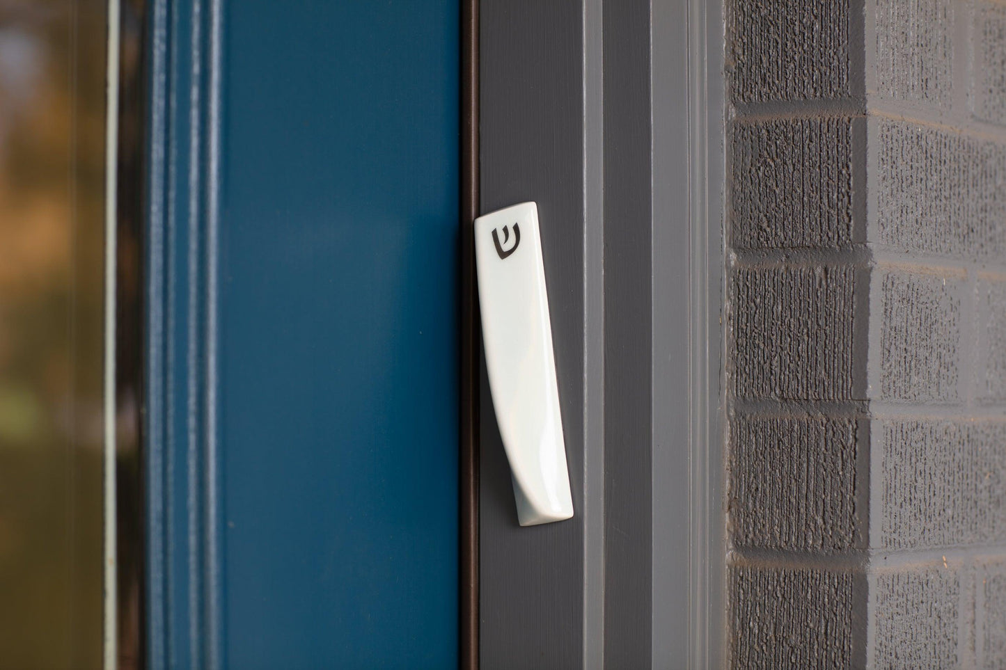 Handcrafted mezuzah affixed to a doorpost, featuring a sleek, modern design with intricate detailing. A symbol of faith and protection, available at Green Judaica.